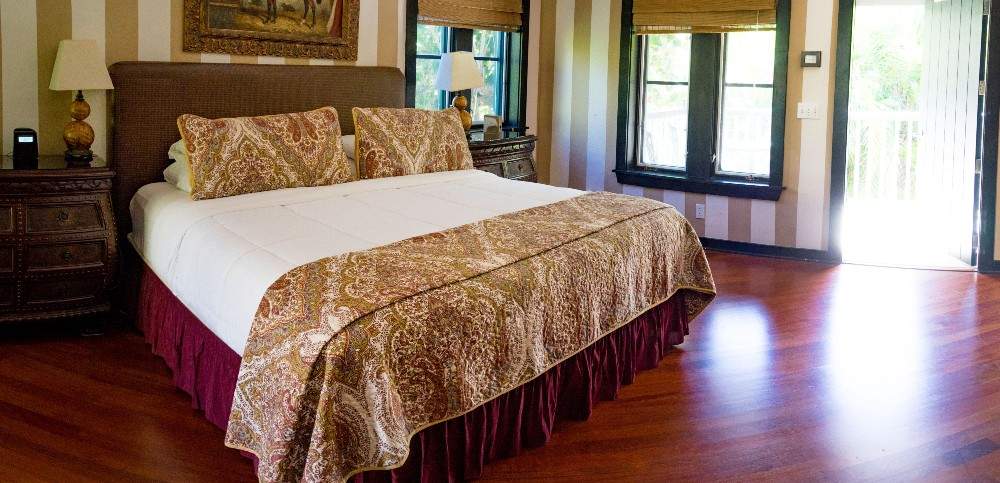 Room with king size bed and mahogany floors