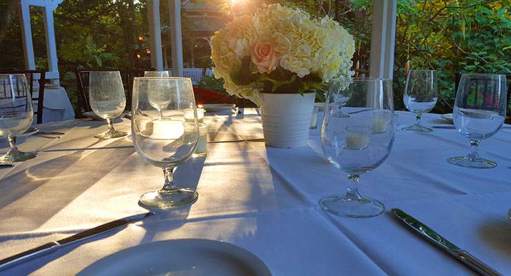 table setting with wine glasses and flower centerpiece