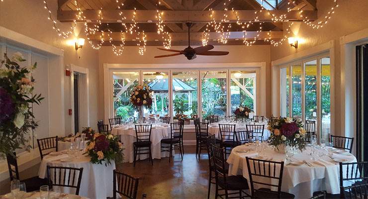 Reception setting of tables with white table cloths and hanging lights