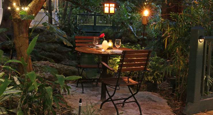 Romantic table for 2 set up at night under trees