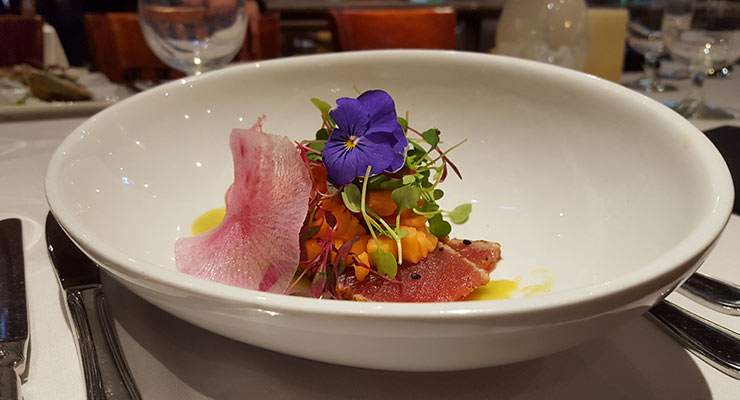 Beautiful dish with pink and purple flower garnishes