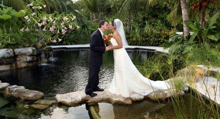 Husband and Wife kissing on a pond 