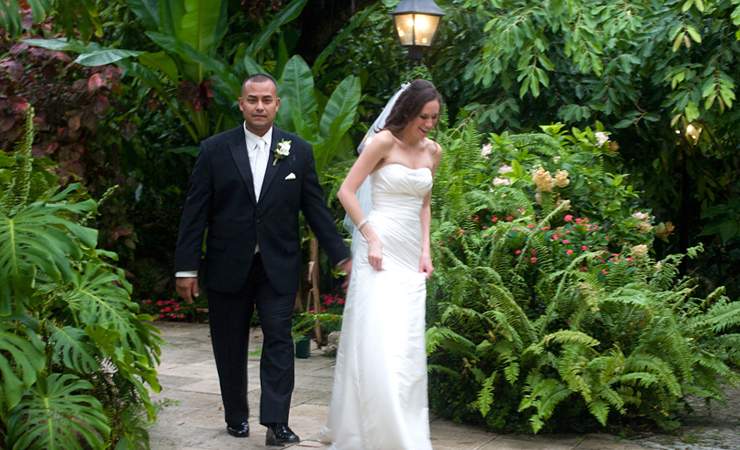 bride and groom walking through the garden 